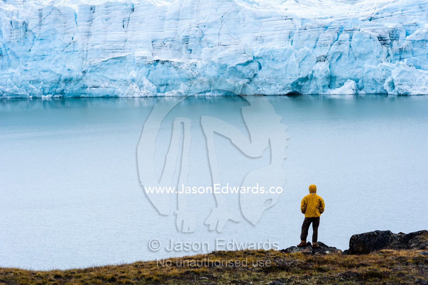 A hiker dwarfed by the fracture zone of a glacier on the Greenland Ice Sheet. Isunngua Highland, Greenland Ice Sheet, Kangerlussuaq, Qeqqata Municipality, Greenland.