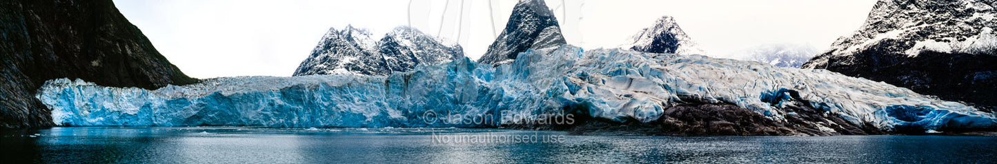 The sheer fracture zone of a glacier sandwiched between alpine peaks in a fjord. Fjord of Eternity, Maniitsoq, Sukkertoppen, Qeqqata Municipality, Greenland.