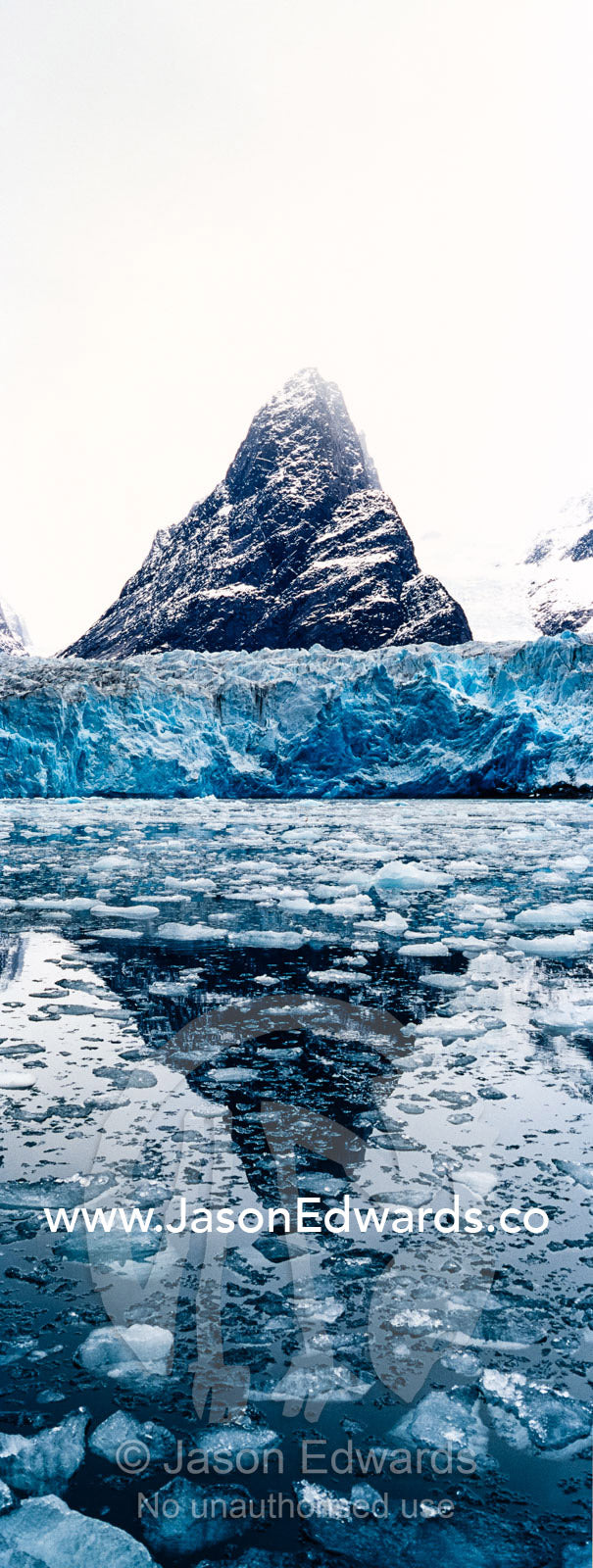 The sheer fracture zone of a glacier sandwiched between alpine peaks in a fjord. Fjord of Eternity, Maniitsoq, Sukkertoppen, Qeqqata Municipality, Greenland.