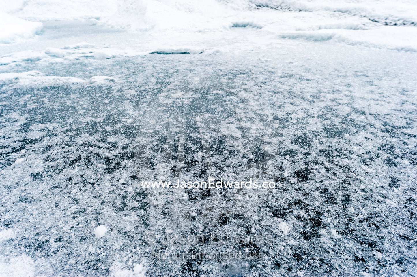The frozen surface of a melt pond on the surface of the Greenland Ice Shelf. Greenland Ice Sheet, Qeqqata Municipality, Kangerlussuaq, Greenland.