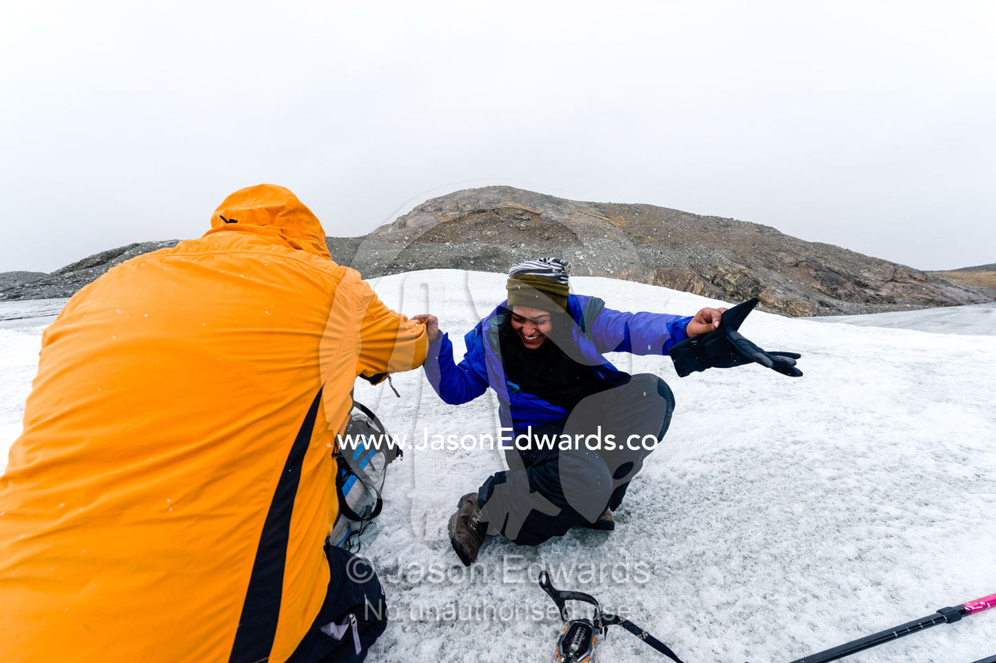 Tourist fitting crampons to their boots to hike on the Greenland Ice Shelf. Isunngua Highland, Greenland Ice Sheet, Kangerlussuaq, Qeqqata Municipality, Greenland.
