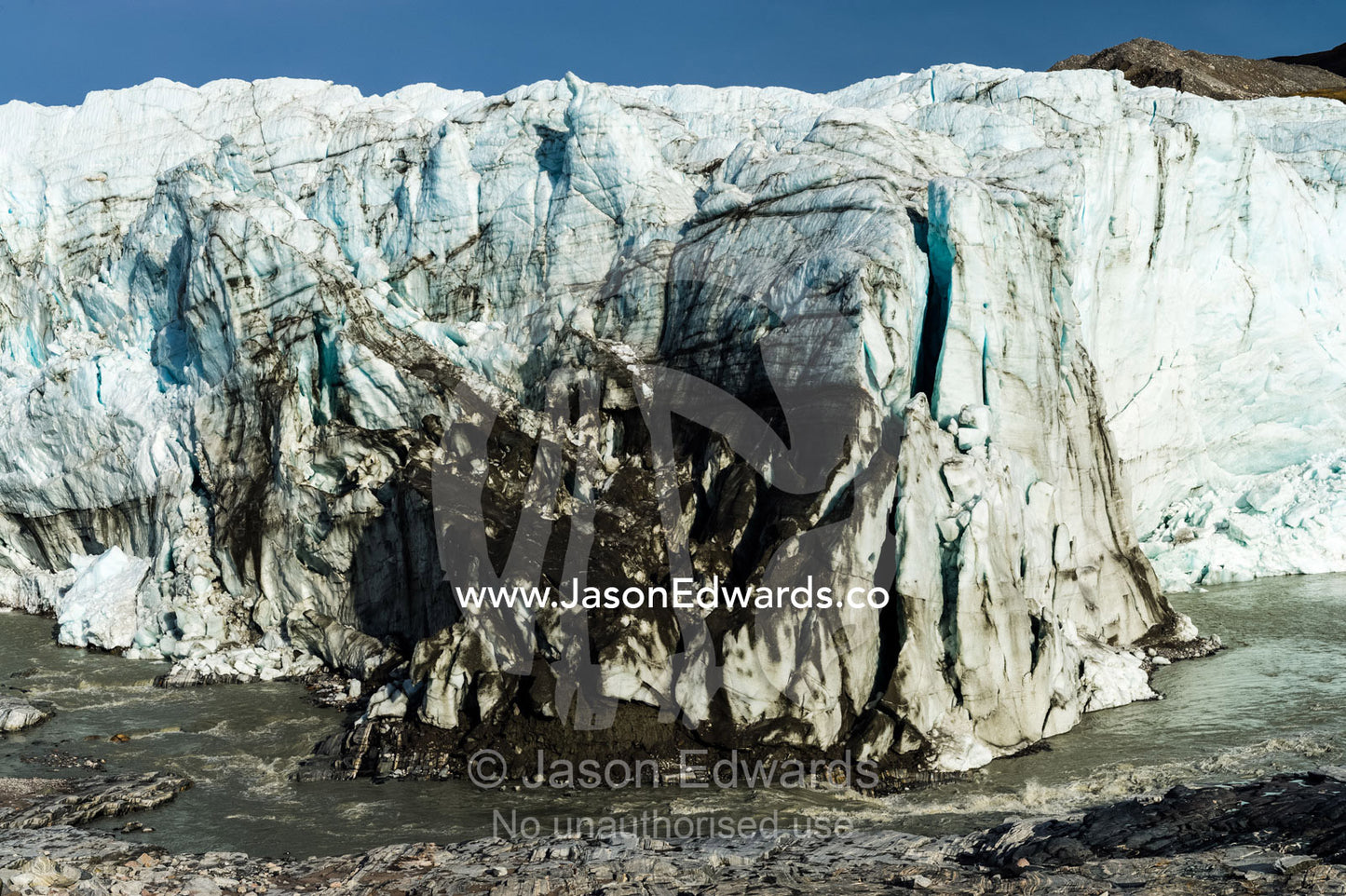 Erosion from ice against rock deposits silt and soil sediment on the face of a glacier fracture zone. Qinnguata Kuussua River, Russell Glacier, Greenland Ice Sheet, Qeqqata Municipality, Kangerlussuaq, Greenland.