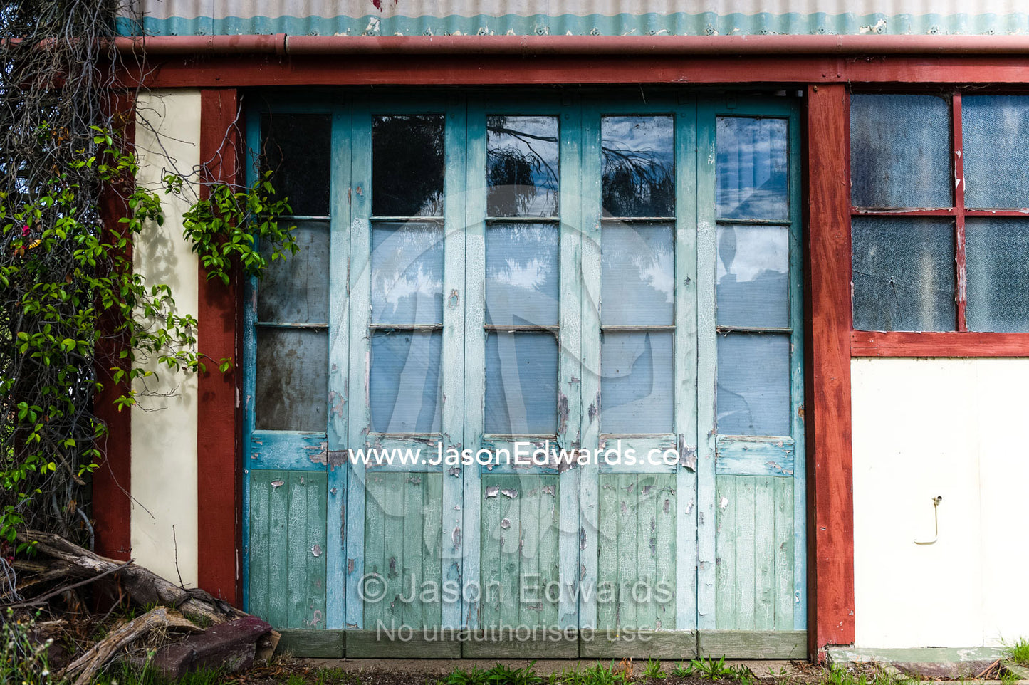 Peeling paint on weathered antique doors in a country town. Avenel, Victoria, Australia.
