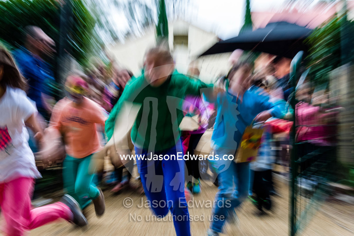 Children run through a gate at the start of an Easter egg hunt. Euroa Butter and Ice Factory, Euroa, Strathbogie, Victoria, Australia.