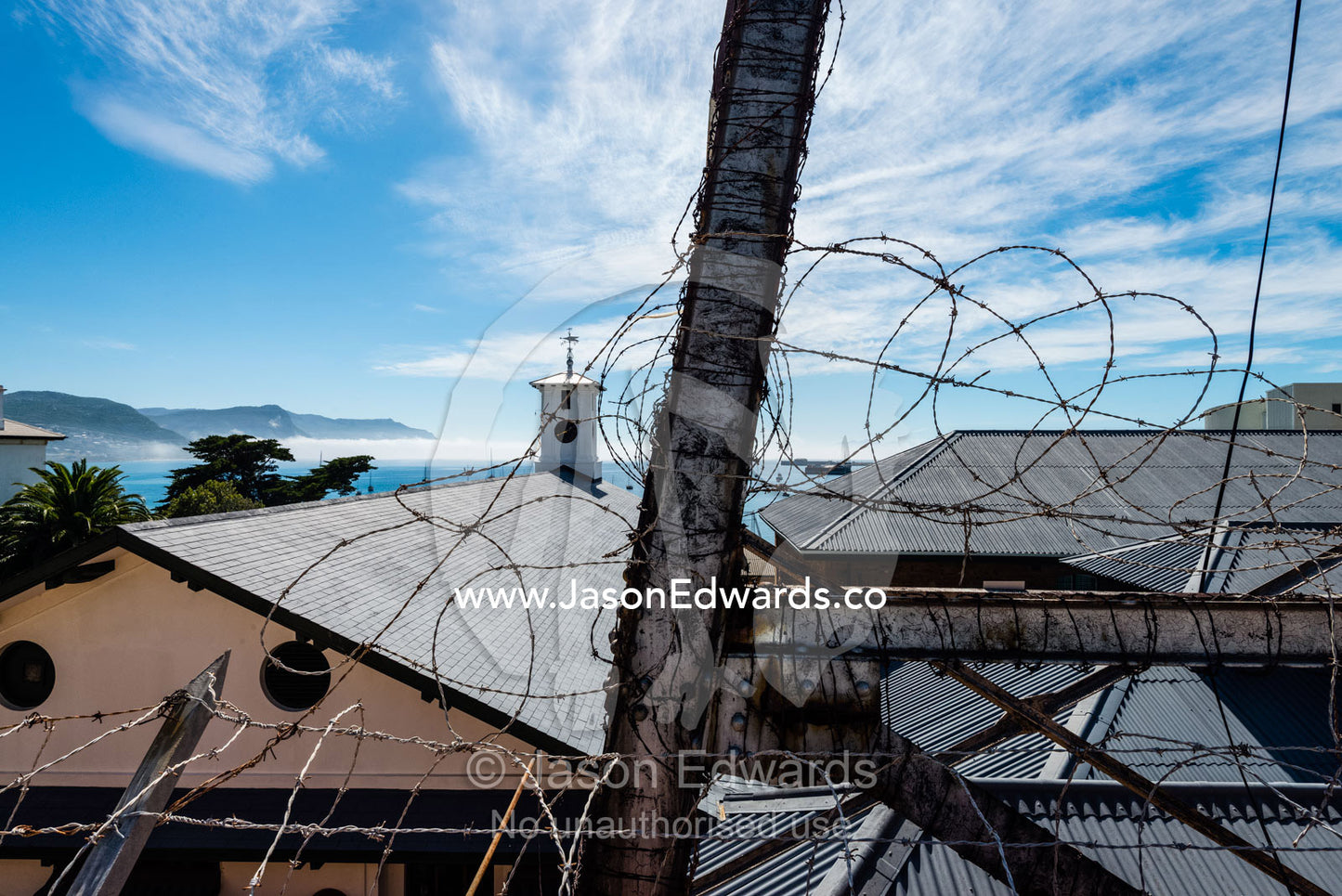 A barbwire fence surrounding a church in a coastal town. Simon's Town Naval Base, Cape Town, False Bay, Cape Peninsula, Chapmans Peak Drive, Western Cape, South Africa.
