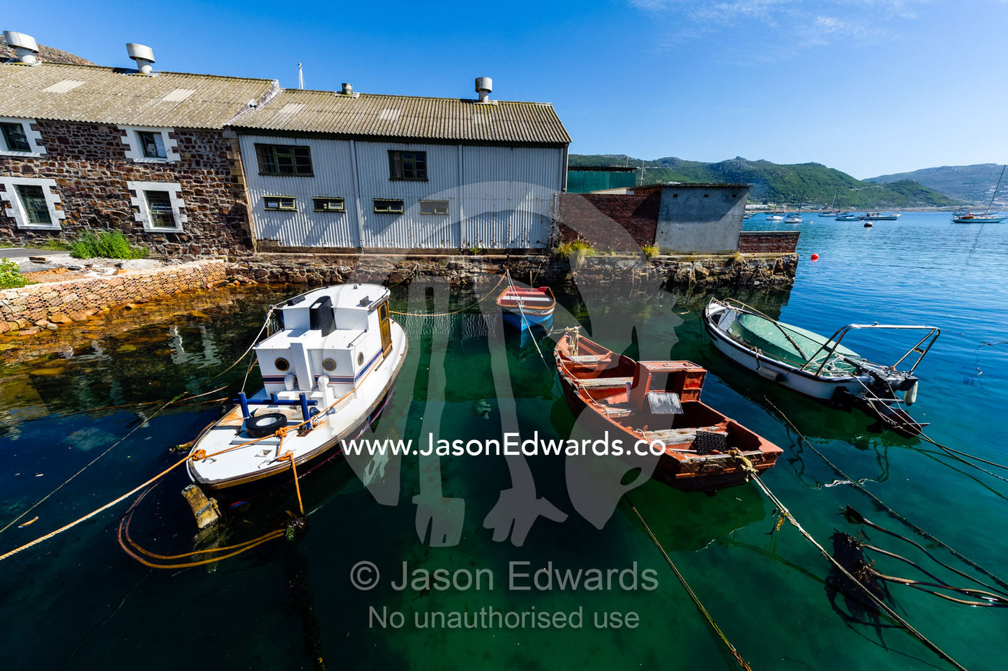 Small fishing boats and punts moored in a tiny bay. Simon's Town Naval Base, Cape Town, False Bay, Cape Peninsula, Chapmans Peak Drive, Western Cape, South Africa.