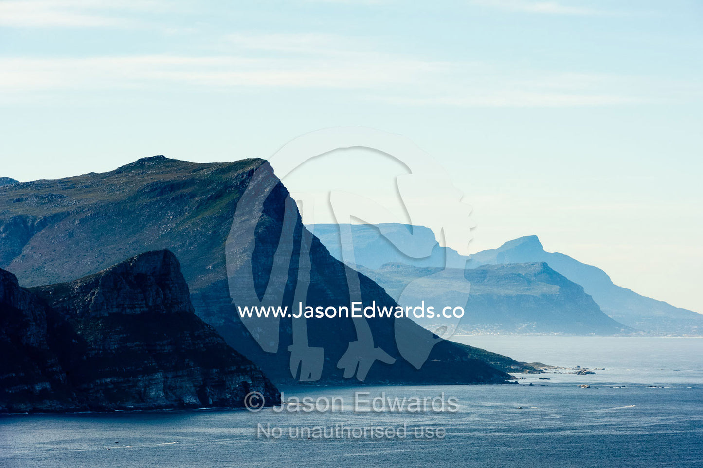 Sheer cliffs and mountain peaks overlooking a blue sea along the Cape of Good Hope. Cape of Good Hope, Cape Point, Table Mountain National Park, Cape Peninsula, South Africa.