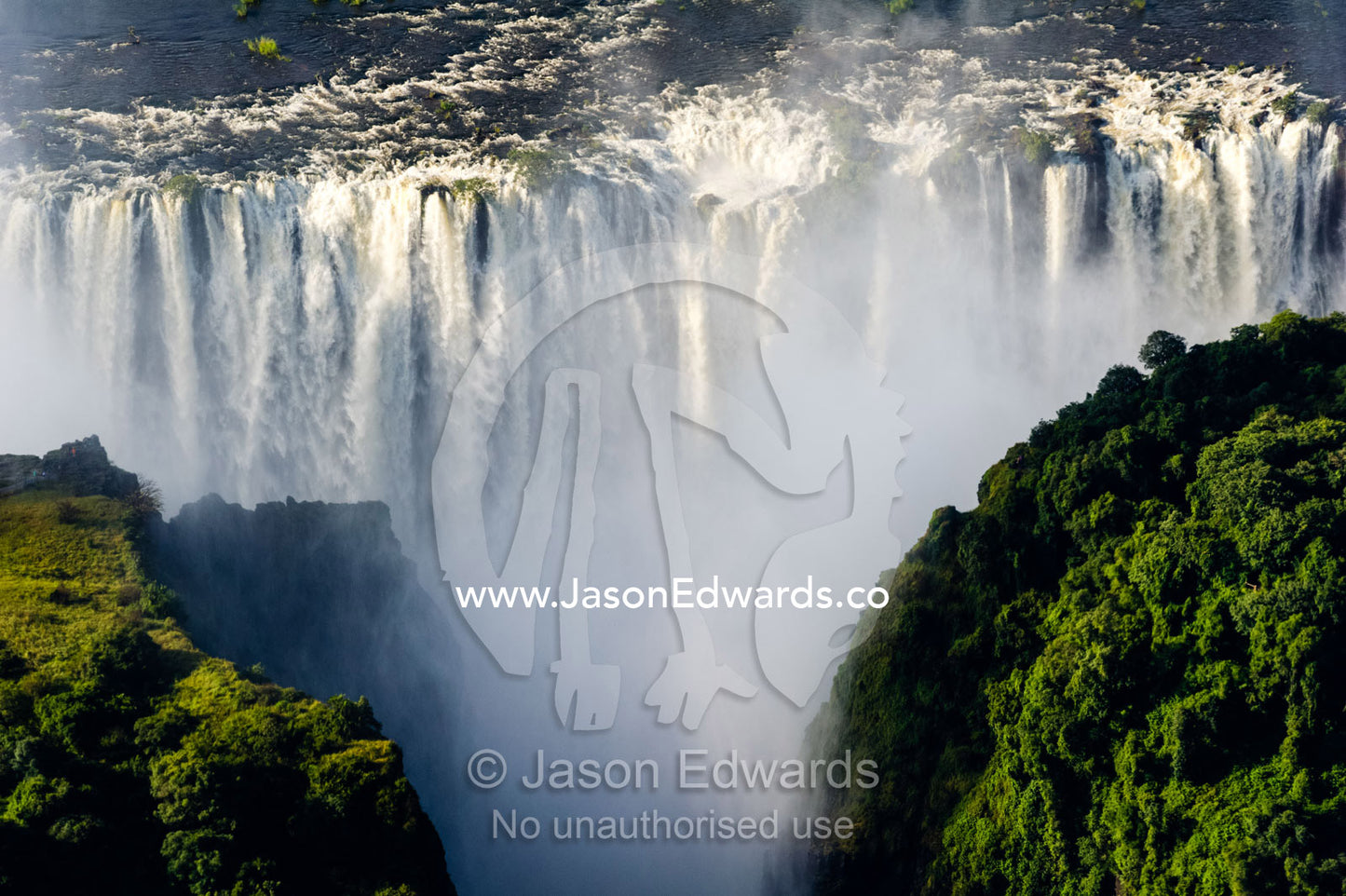 The flooded waters of the Zambezi River cascade in a curtain across the face of Victoria Falls. Zambezi River, Victoria Falls, Mosi-oa-Tunya National Park, Victoria Falls National Park, Zambia.