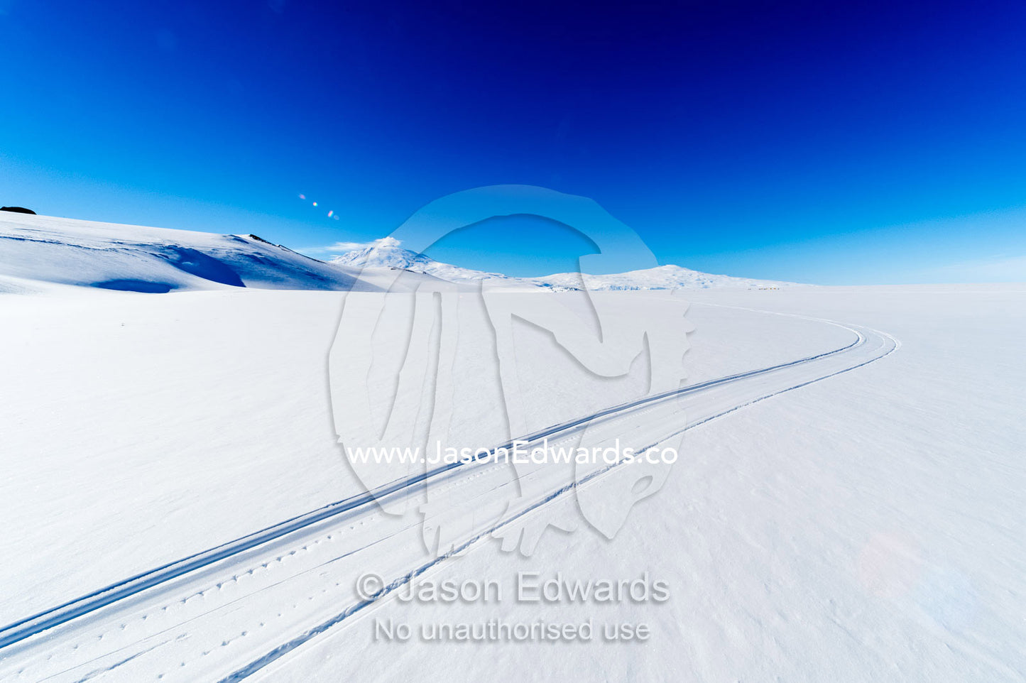 Skiddoo tracks cross the snow on the vast barren Ross Ice Shelf. Windless Bight, Ross Ice Shelf, Ross Island, Antarctica.