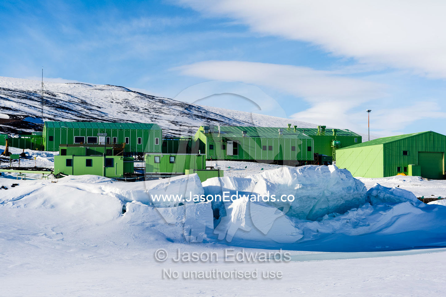 Sea ice pressure ridges rise along the shoreline in front of Scott Base in Antarctica. Scott Base, Pram Point, Hut Point Peninsula, Ross Island, Antarctica.