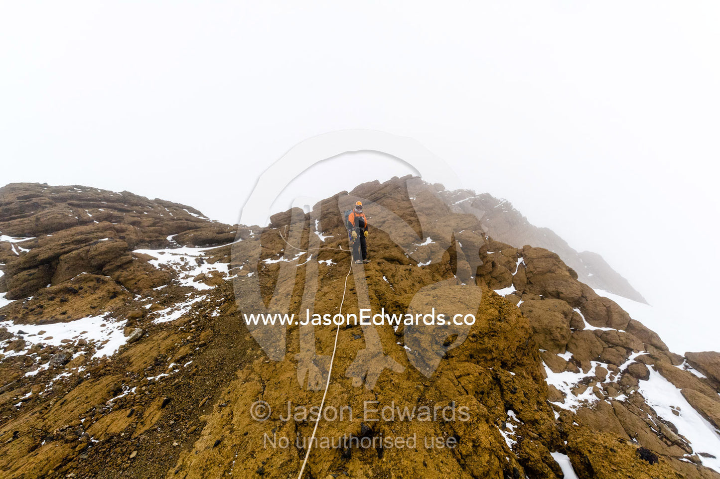 Mountain climbers using climbing ropes to scale a cliff overlooking the Ross Ice Shelf. Castle Rock, Hut Point Peninsula, Ross Island, Antarctica.