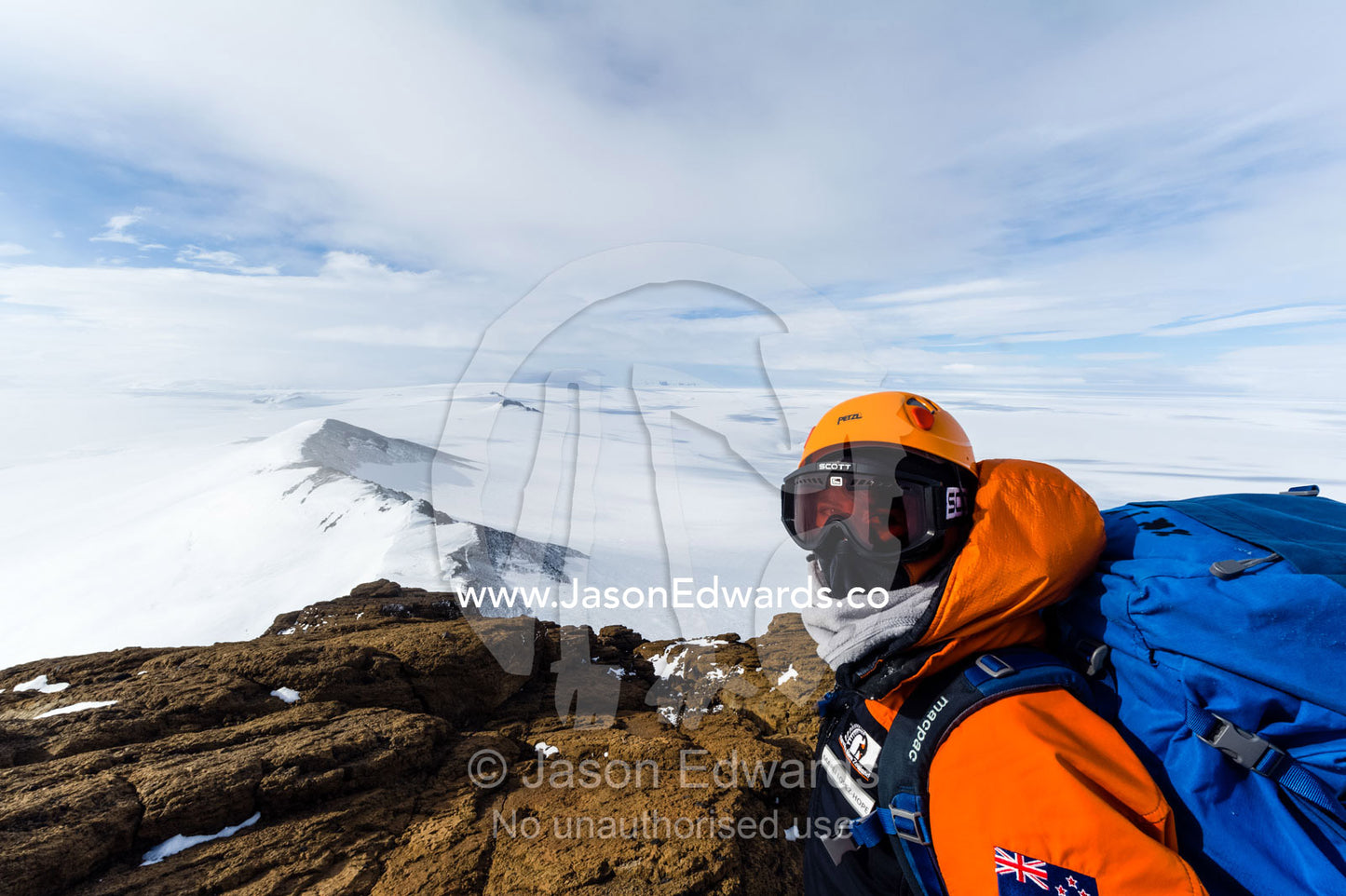 A mountain climber views Mount Erebus an active volcano from a mountaintop. Castle Rock, Hut Point Peninsula, Ross Island, Antarctica.