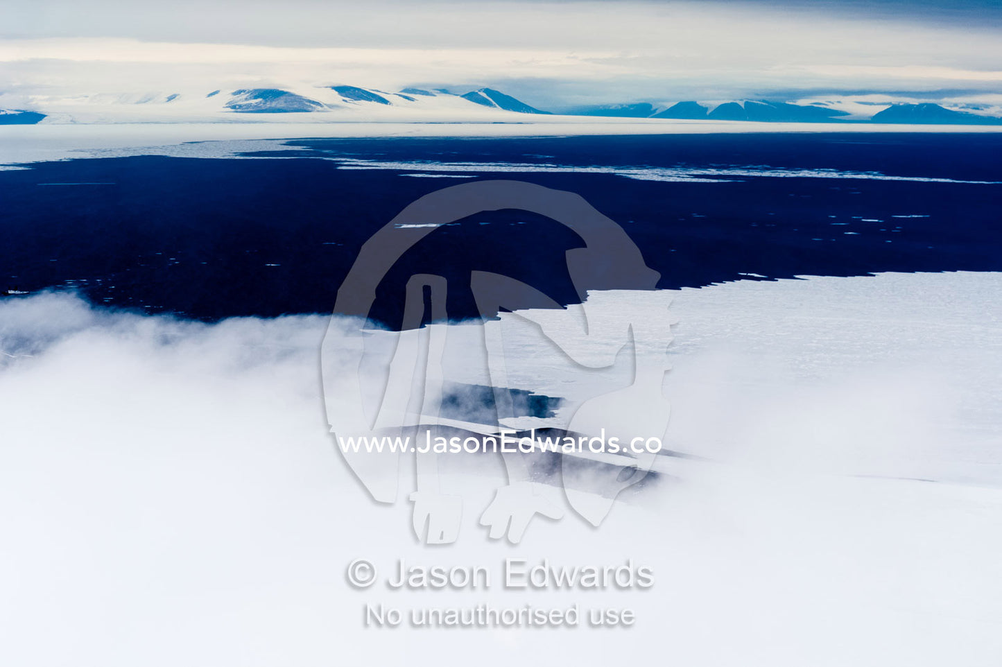 Mist and cloud shroud the sea ice near open ocean in the Antarctic summer. McMurdo Sound, Ross Island, Antarctica.
