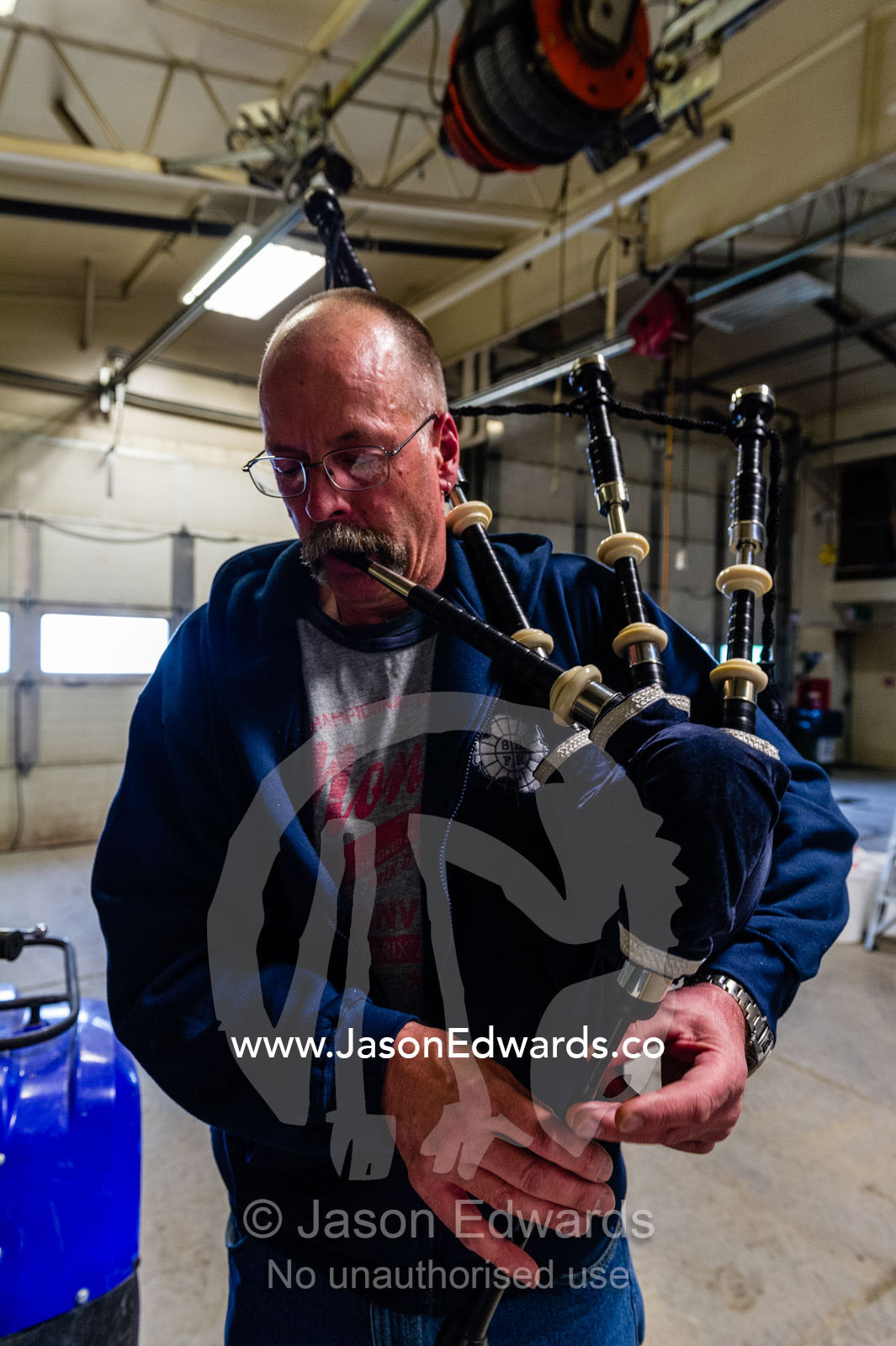 A tradesman on an Antarctic base practices the bagpipes in his workshop. Scott Base, Pram Point, Hut Point Peninsula, Ross Island, Antarctica.