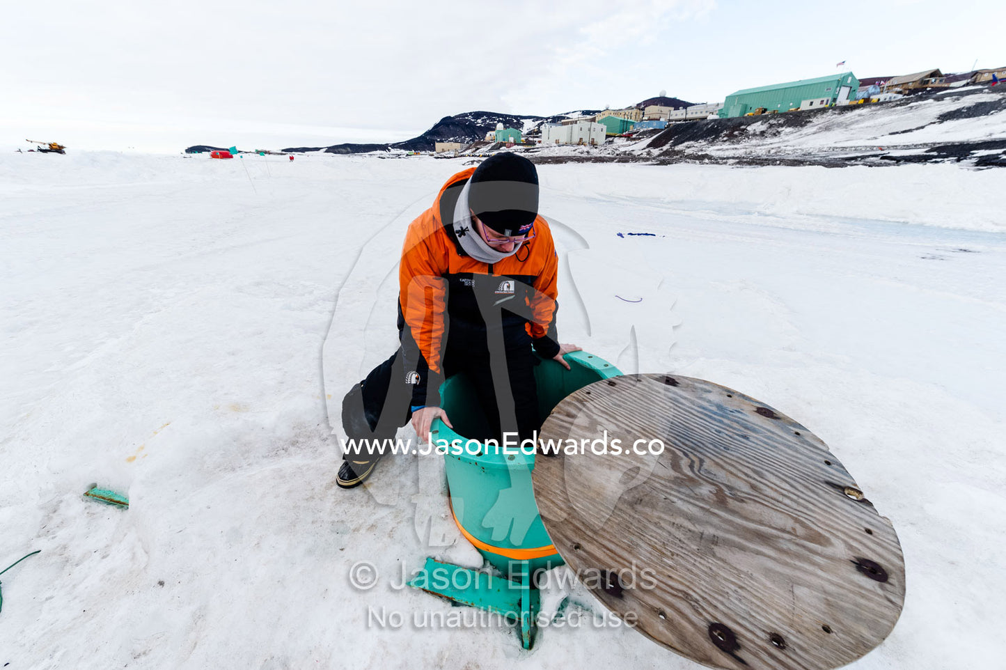 An army engineer descends through the sea ice into a steel observation tube. McMurdo Sound, McMurdo Station, Ross Island, Antarctica.