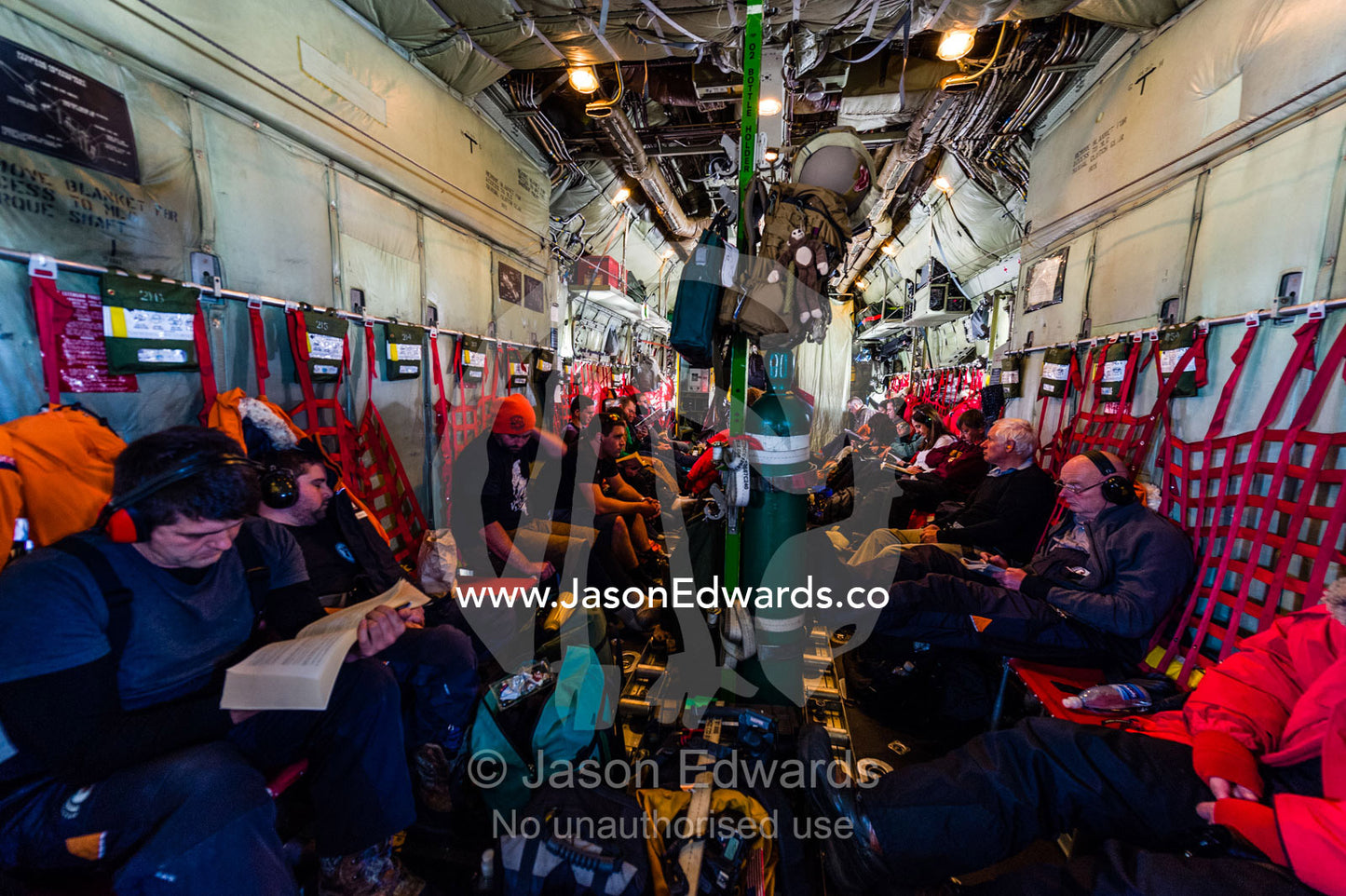 Scientists and staff passengers inside a US Air force Hercules fuselage flying to Antarctica. Southern Ocean, between New Zealand and Antarctica.