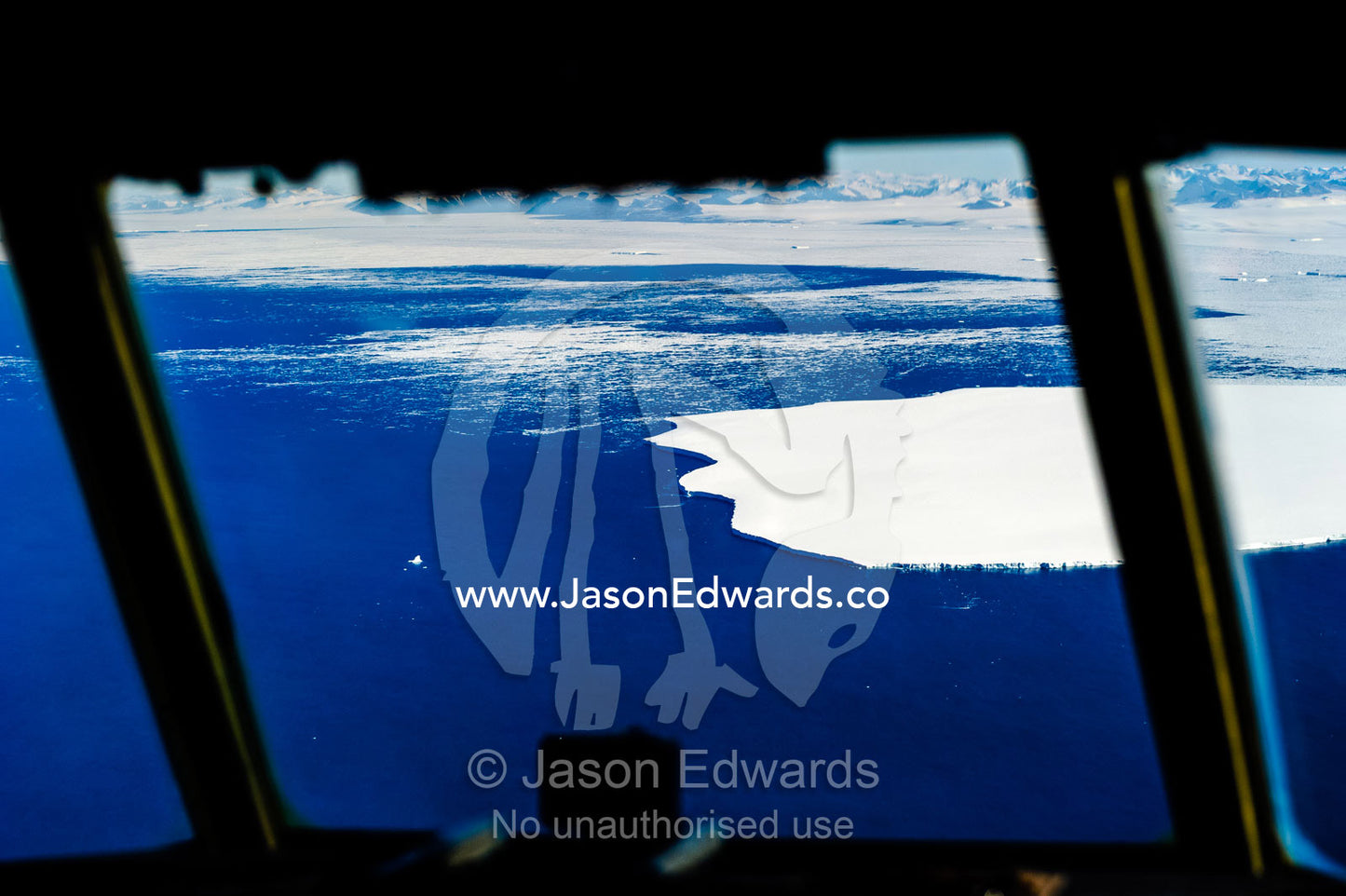 The leading ice edge of a glacier during the Antarctic summer through a Hercules cockpit window. Ross Sea, Antarctica.