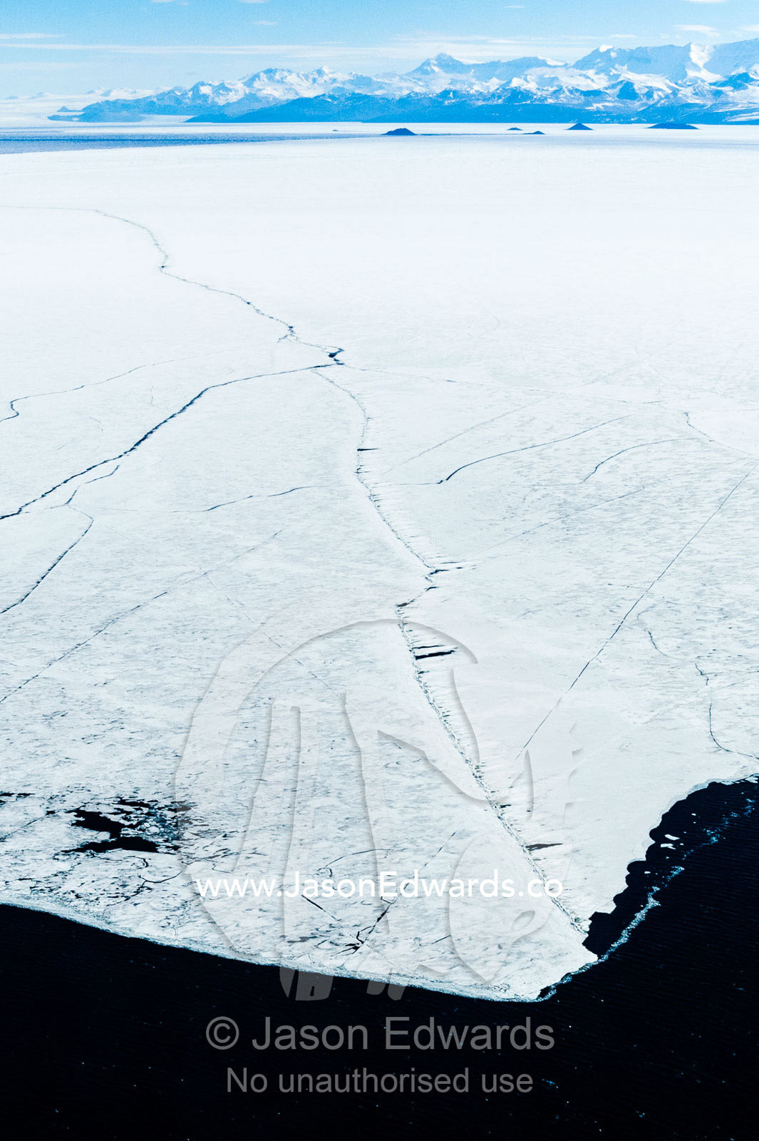 The trail of a Coast Guard icebreaker leaves a crack dissecting a plate of sea ice. McMurdo Sound, Ross Sea, Antarctica.