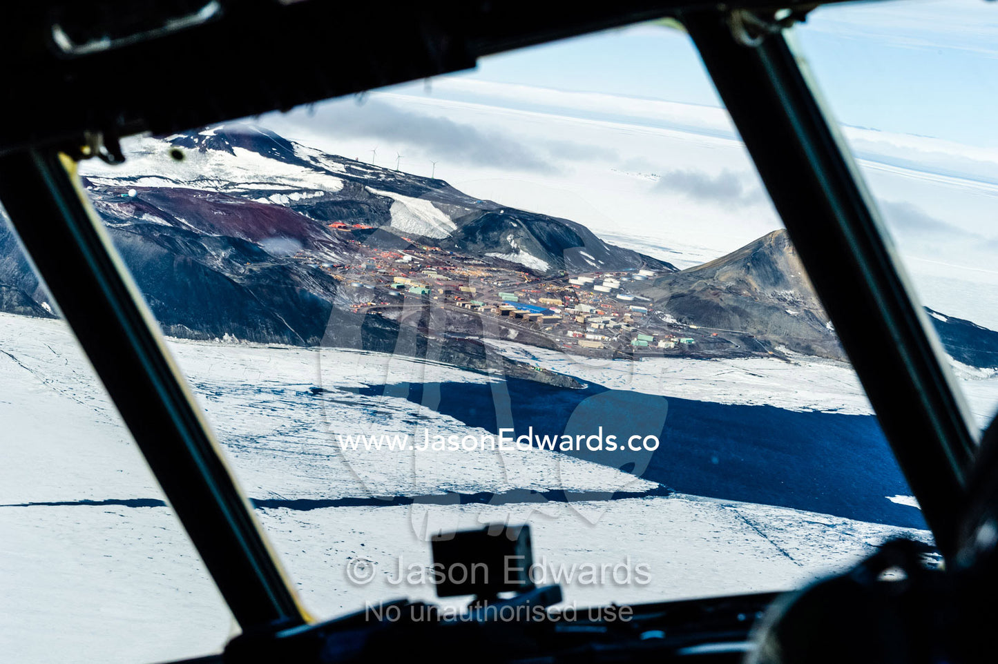 The view of McMurdo Station beneath Observation Hill through the cockpit of a US Air force Hercules cockpit. McMurdo Station, Ross Island, Antarctica.