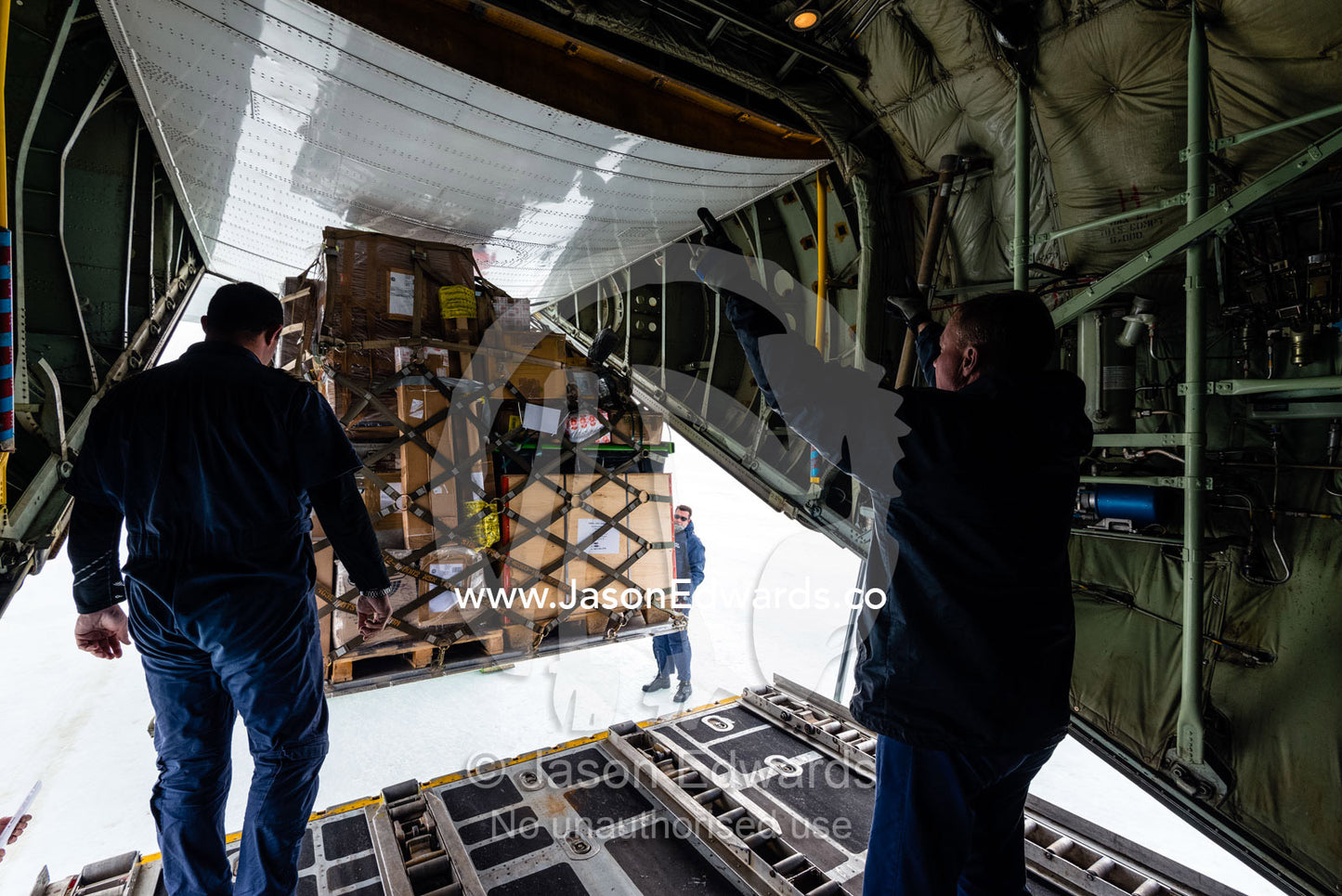 The South African crew of a US Air force Hercules unloading cargo to an Italian base in Antarctica. Zucchelli Station, Terra Nova Bay, Victoria Land, Antarctica.