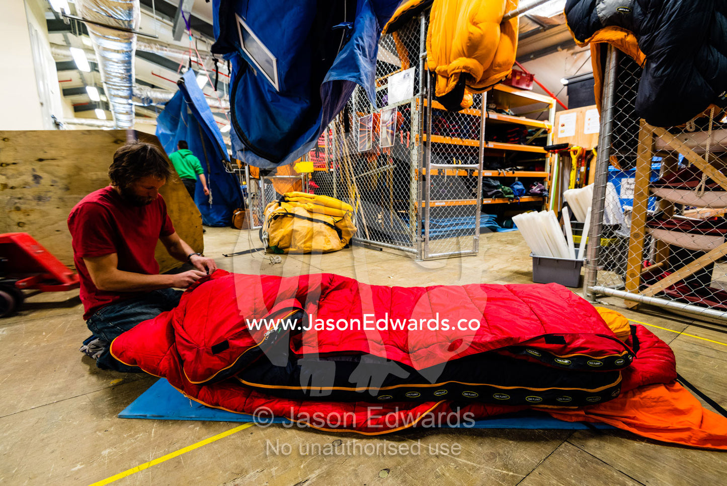 A survival guide and field expert prepares a sleeping bag for camping on the sea ice. Scott Base, Pram Point, Hut Point Peninsula, Ross Island, Antarctica.