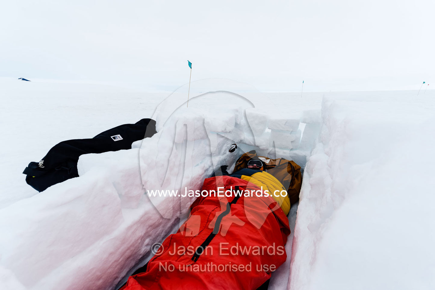 Antarctic base staff in a sleeping bag in a sleeping pit in the sea ice carved from blocks of ice. Windless Bight, Ross Ice Shelf, Ross Island, Antarctica.