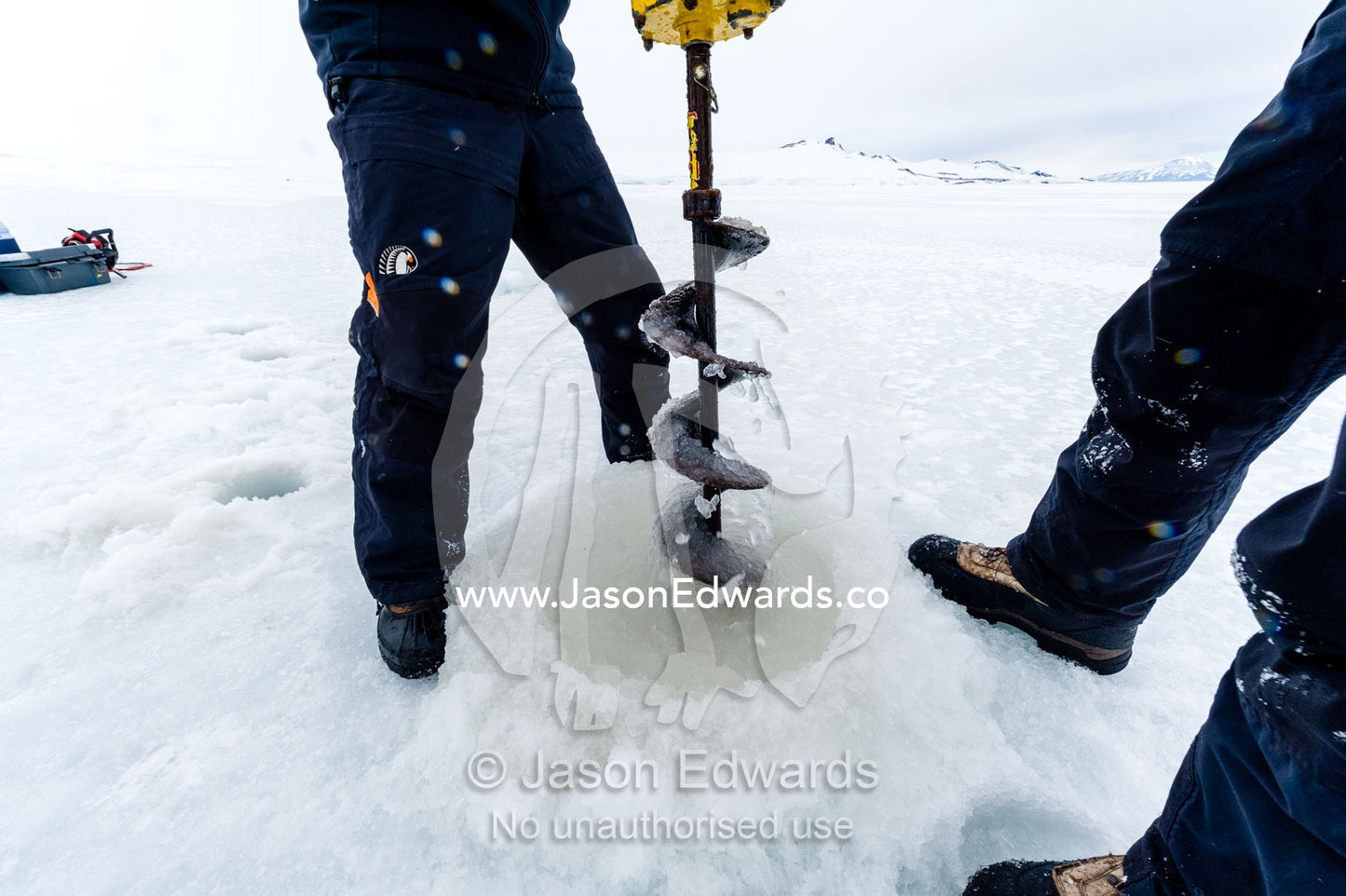 Researchers drill core samples from the sea ice to collect extremophiles from the ocean beneath the ice to study. Turtle Rock, Erebus Bay, McMurdo Sound, Ross Island, Antarctica.