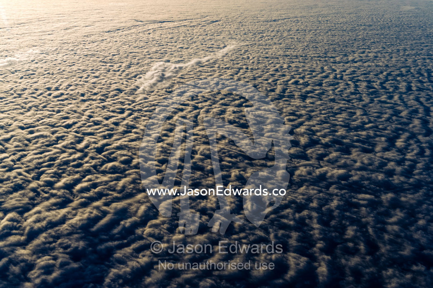 Sunset touches the surface of a cloud bank over the Southern Ocean. Southern Ocean, between New Zealand and Antarctica.