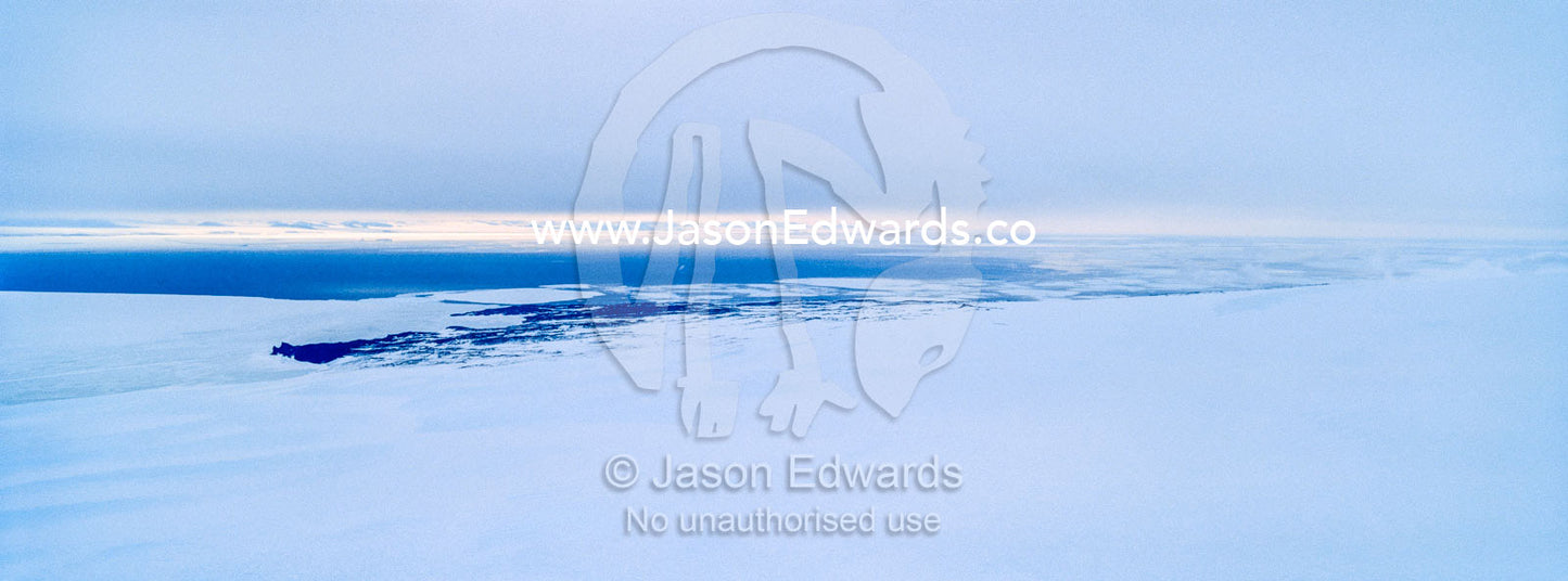 Cloud descends over the frozen sea ice and ocean ice edge. McMurdo Sound, Ross Sea, Antarctica.