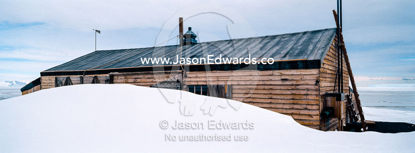 The weathered walls and window shutters of the Antarctic explorer Robert Falcon Scott's hut surrounded by snow. Scott's Hut, Cape Evans, Ross Island, Antarctica.