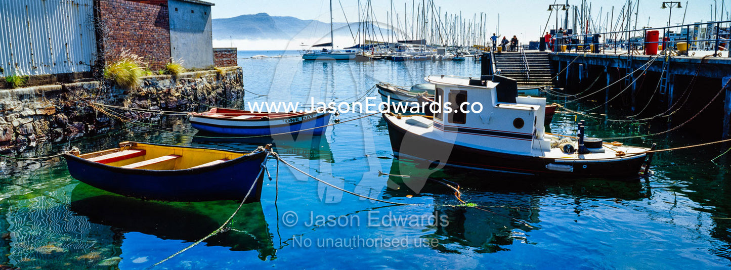 Small fishing boats and punts moored in a tiny bay. Simon's Town Naval Base, Cape Town, False Bay, Cape Peninsula, Chapmans Peak Drive, Western Cape, South Africa.