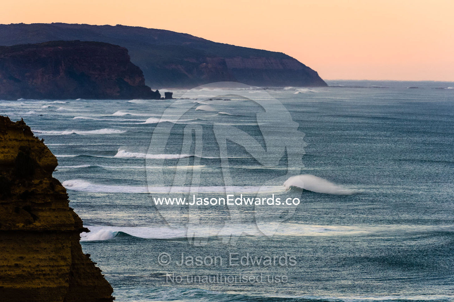 A line of perfect surfing waves crashing along a spectacular coast. Twelve Apostles, Port Campbell National, Great Ocean Road, Victoria, Australia.
