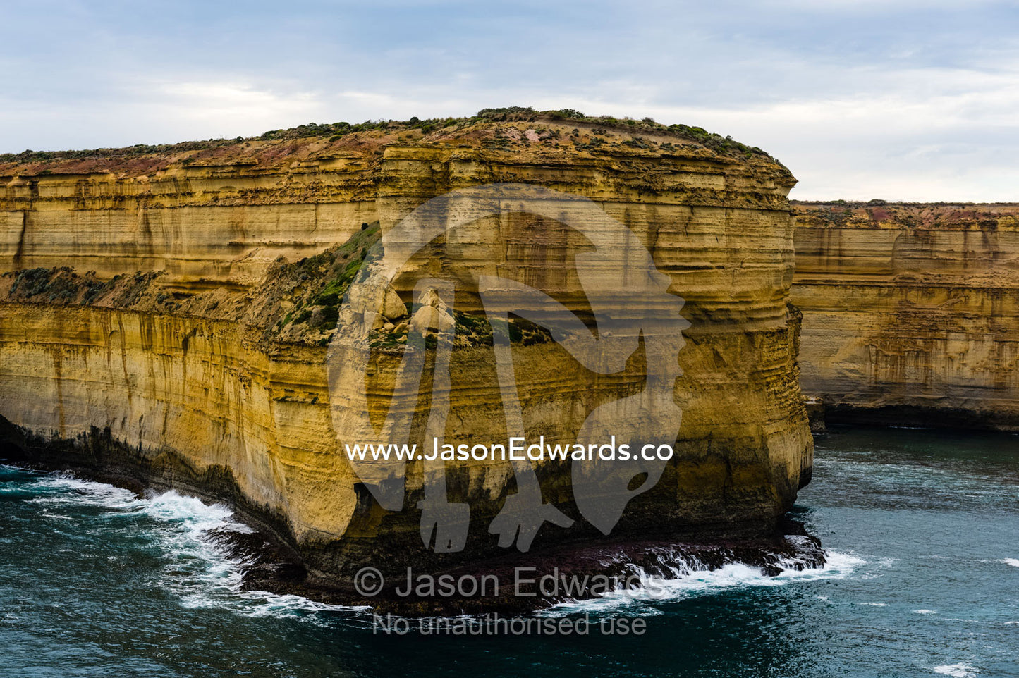 An aerial view of the ocean and the erosion on the sheer limestone cliffs and bays. Twelve Apostles, Port Campbell National, Great Ocean Road, Victoria, Australia.