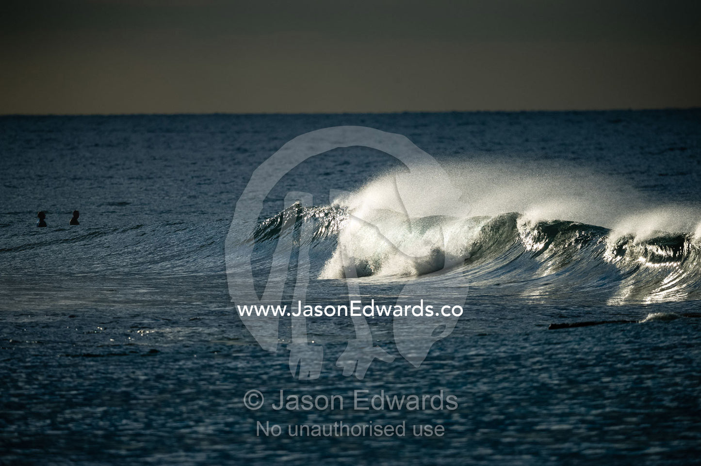 A ray of sun catches the curling lip of a wave breaking at a surf location. Winkipop, Bells Beach, Great Ocean Road, Victoria, Australia