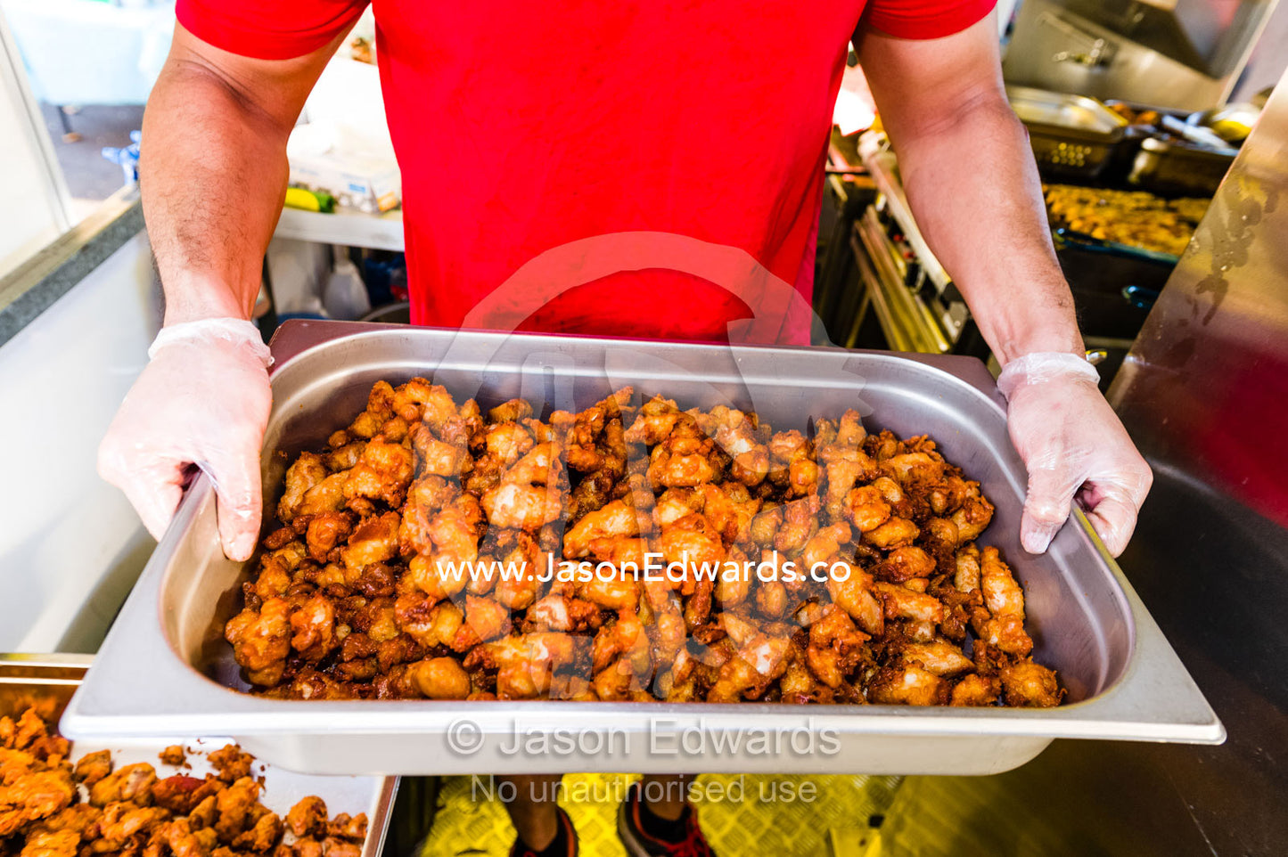 Spicy chicken pieces in a cooking tray in a mobile restaurant. Mindil Beach Sunset Markets, Darwin, Northern Territory, Australia.