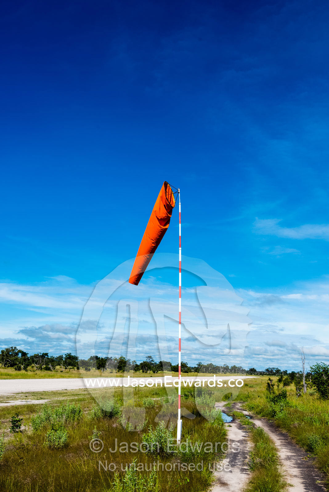 A wind sock shows the direction of the breeze on a bush airstrip. Zarafa Camp, Zibadianja Lagoon, Savute Channel, Linyanti, Botswana.