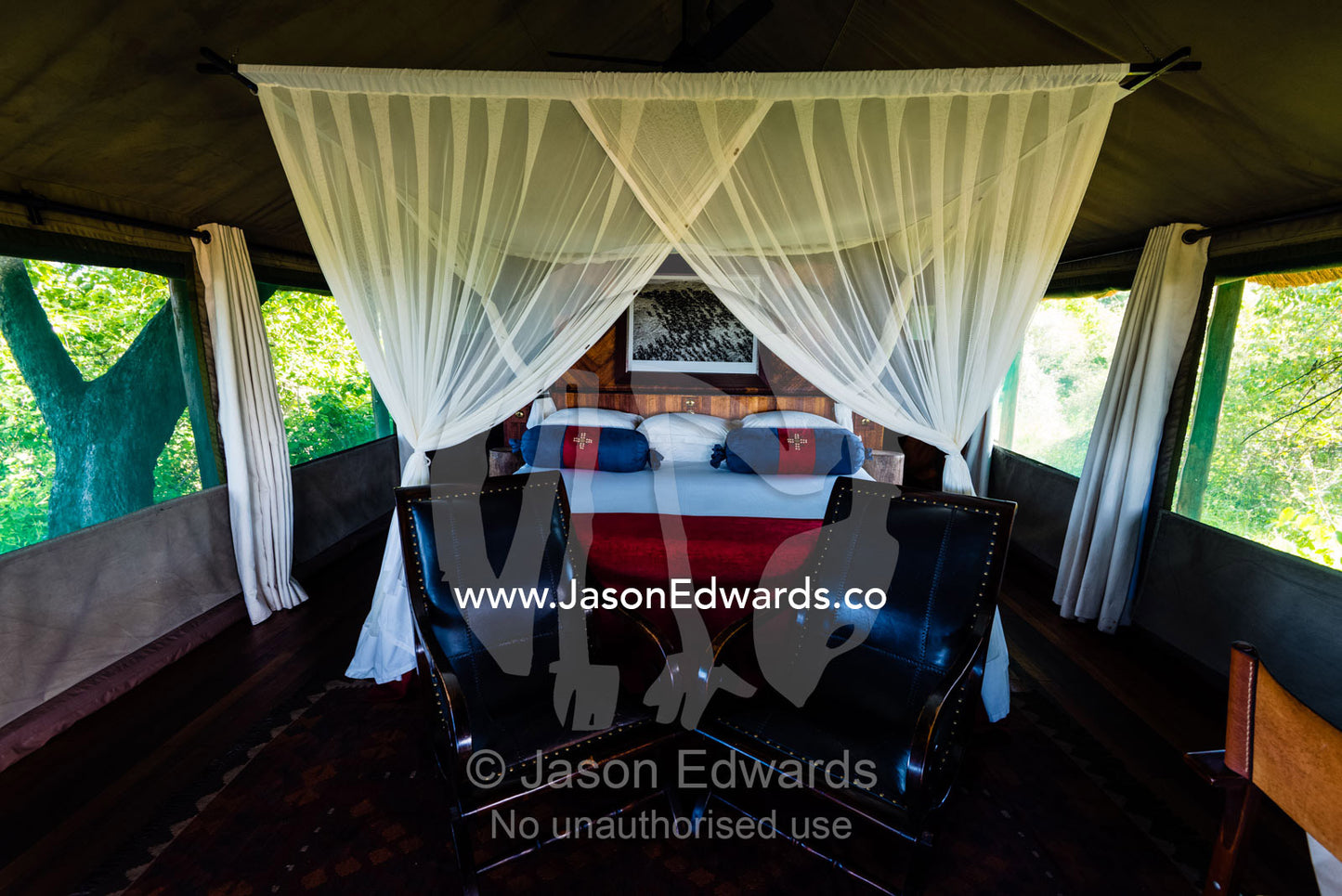 A mosquito net around a bed in a luxurious safari camp tent. Selinda Camp, Selinda Reserve, Linyanti Region, Northern Botswana.