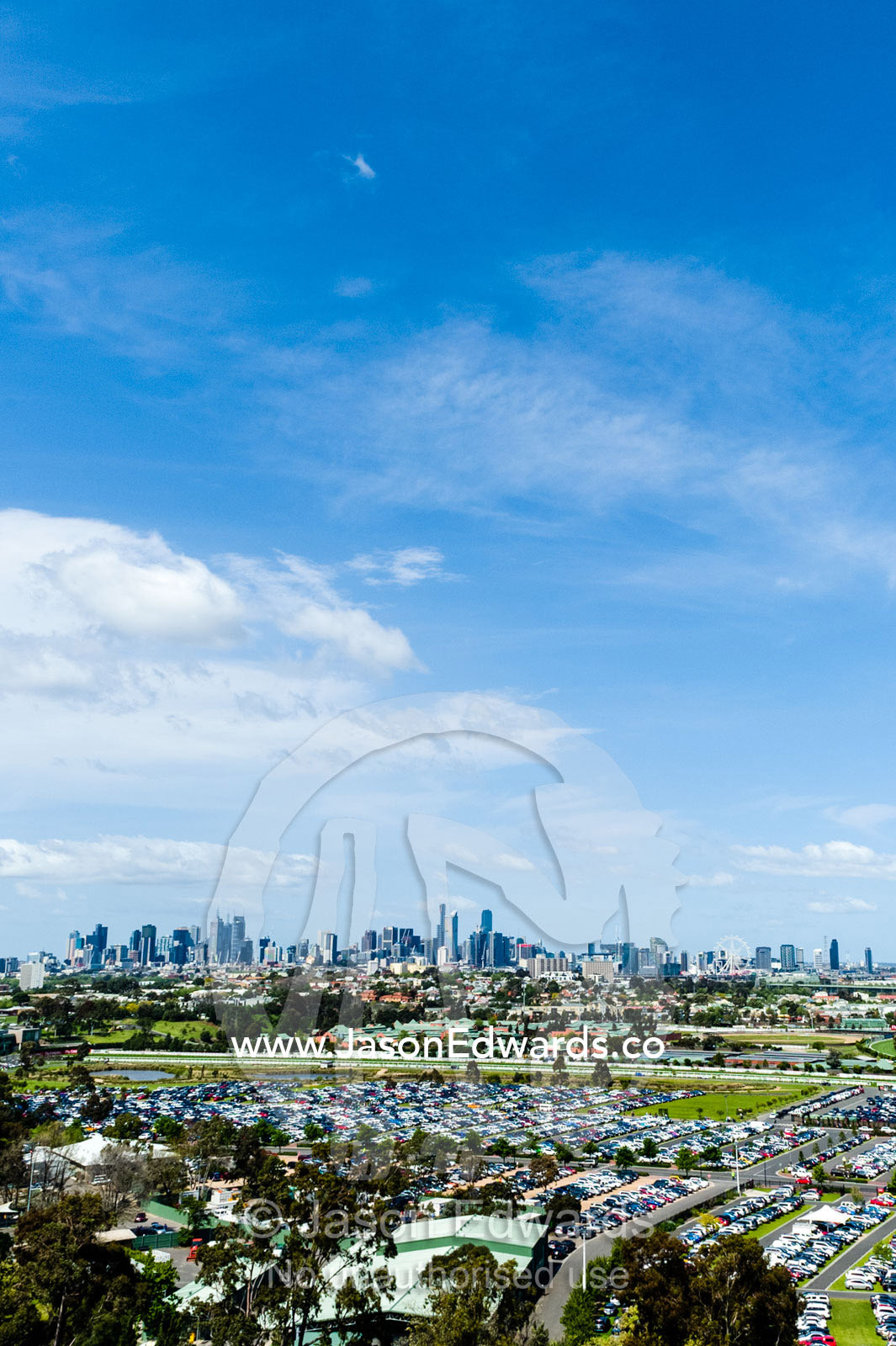 A car park full of traffic at an agricultural show with the city skyline in the background. Royal Melbourne Show, Flemington, Melbourne, Victoria, Australia.