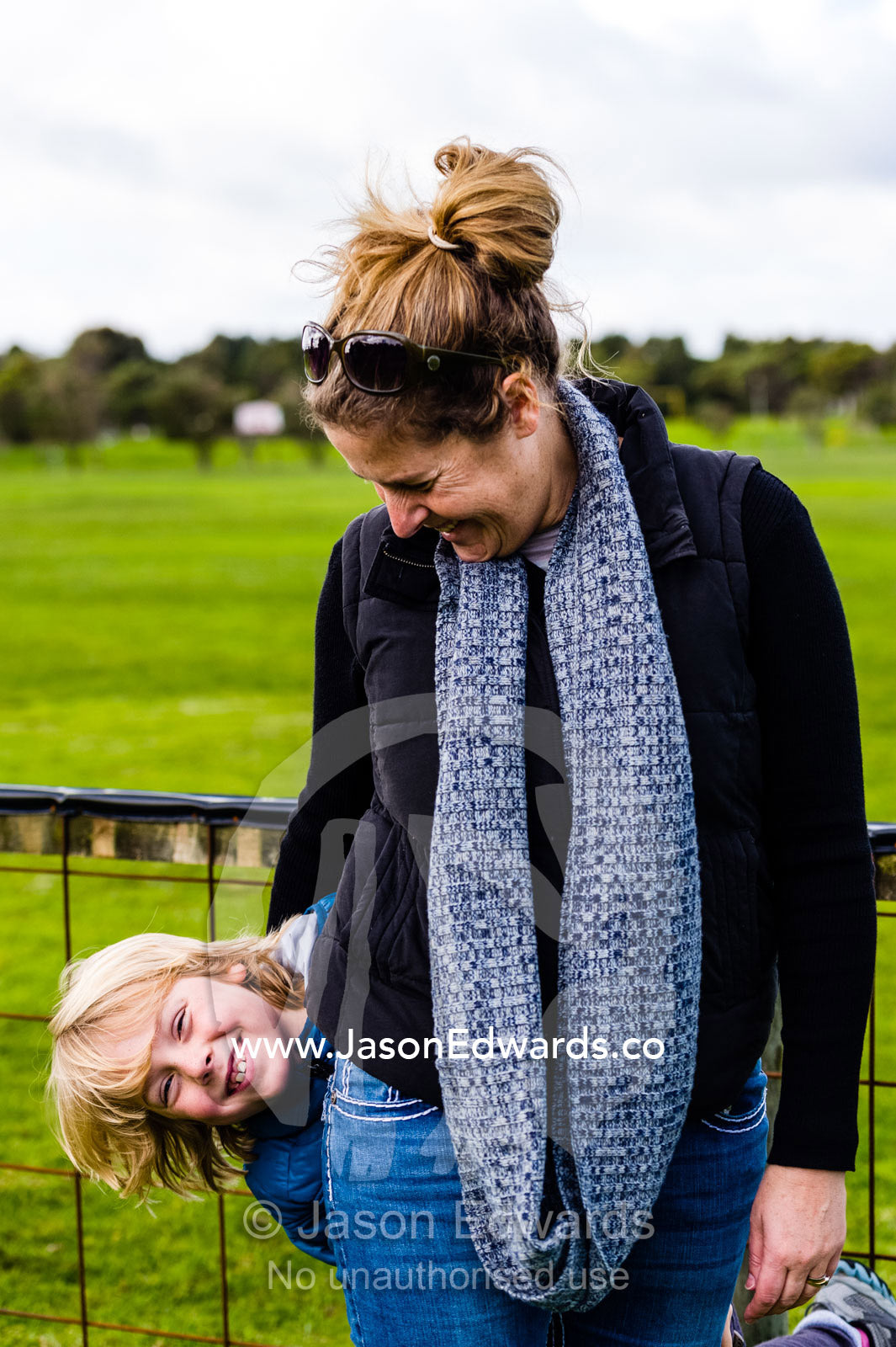 A mother and son waiting at an airfield for her husband to do his first parachute jump. Torquay, Surf Coast, Victoria, Australia.