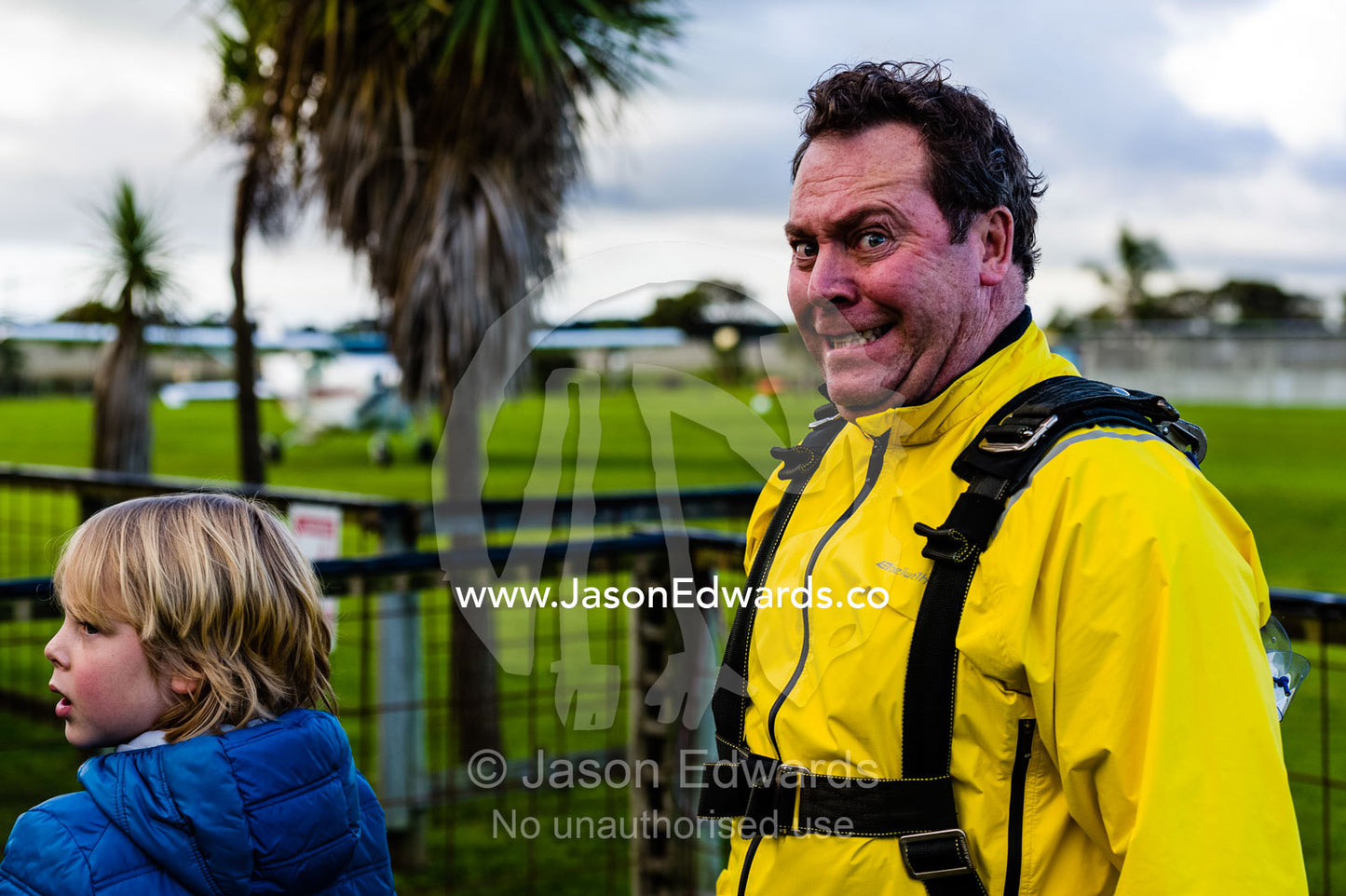 A nervous husband waits with his son at an airfield to do his first parachute jump. Torquay, Surf Coast, Victoria, Australia.