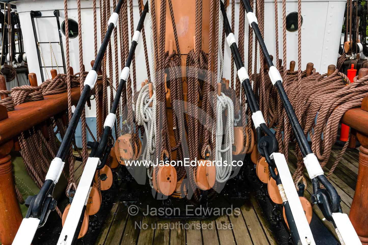 Ropes coiled through pulleys on the mast of a sailing ship in a museum. Polly Woodside, South Wharf Precinct, Yarra River, Melbourne, Victoria, Australia.