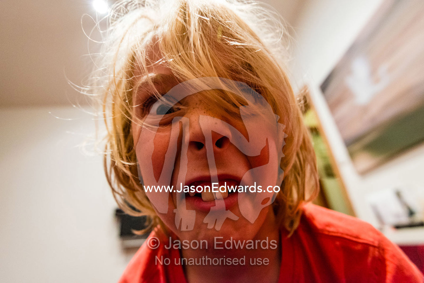 A boy showing his front teeth makes disgusted faces at the camera. Polly Woodside, South Wharf Precinct, Yarra River, Melbourne, Victoria, Australia.