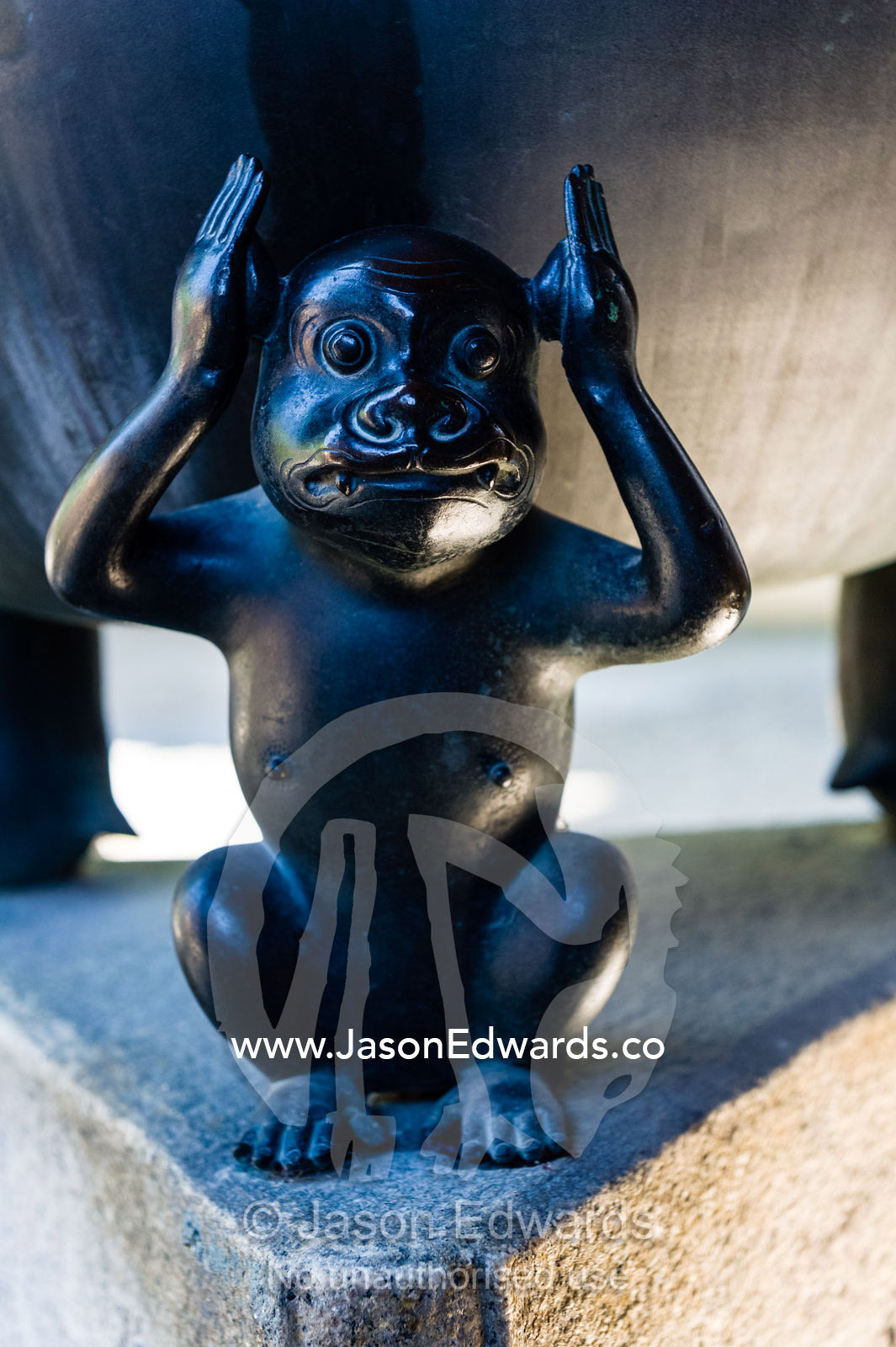 The three monkeys of the Koshin faith represent not hearing, not seeing and not talking supporting a bowl sculpture. Yasaka Koshin-do Temple, Higashiyama, Kyoto, Japan.