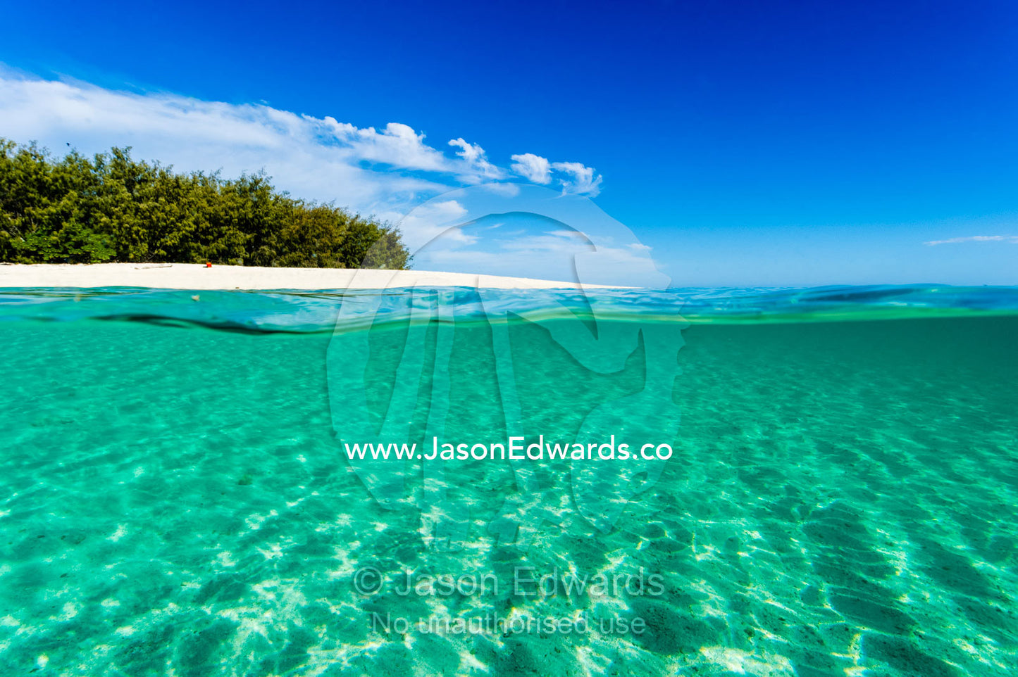 The shallow turquoise waters and white sandy ocean floor near a tropical island. Wreck Beach, Heron Island, Great Barrier Reef, Queensland, Australia.