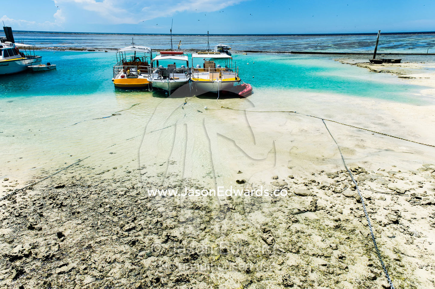 Dive boats resting on the sandy ocean floor at low tide. Heron Island Harbour, Heron Island, Great Barrier Reef, Queensland, Australia.