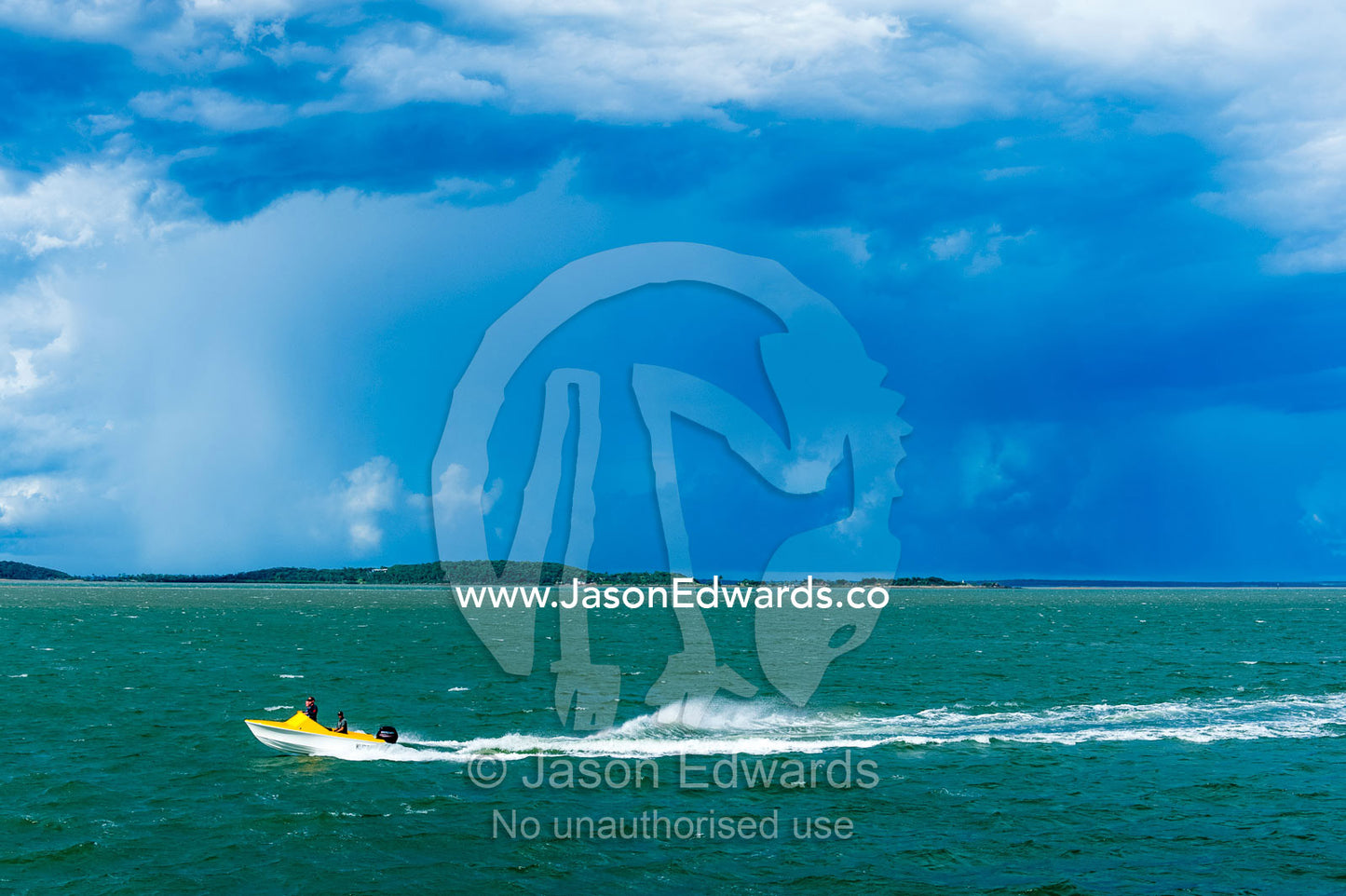 A small speed boat races across the ocean ahead of a storm. Gladstone, Queensland, Australia.