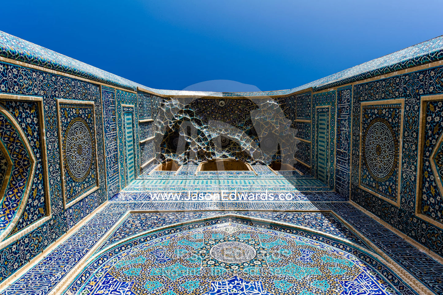The towering blue tiled minarets above the vaulted iwan of the Jame Mosque rise into a clear blue sky. Jame Mosque of Yazd, Yazd, Yazd Province, Islamic Republic of Iran.