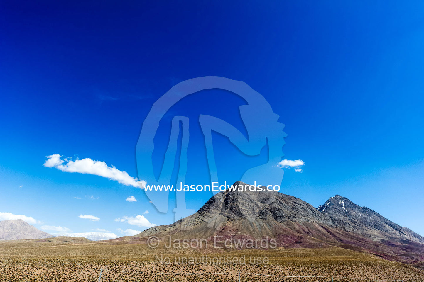 Erosion on the slopes of jagged desert mountain peaks beneath a clear blue sky. Shir Kuh Mountain, Yazd, Yazd Province, Islamic Republic of Iran.