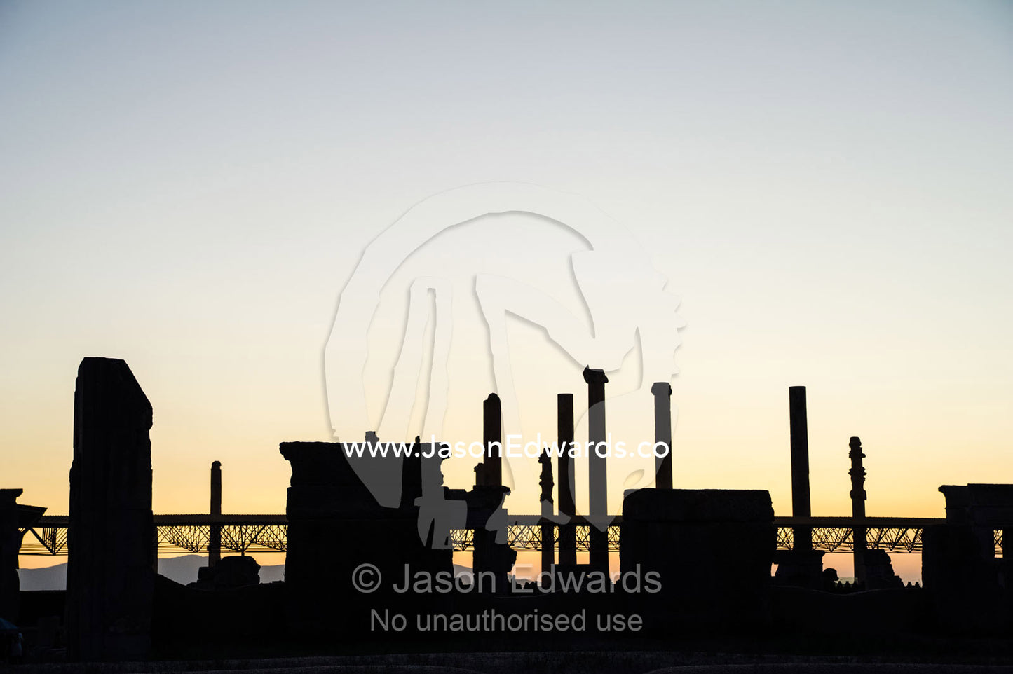 The ancient ruins of Persepolis silhouette on the horizon at sunset. Persepolis, Shiraz, Fars Province, Islamic Republic of Iran.