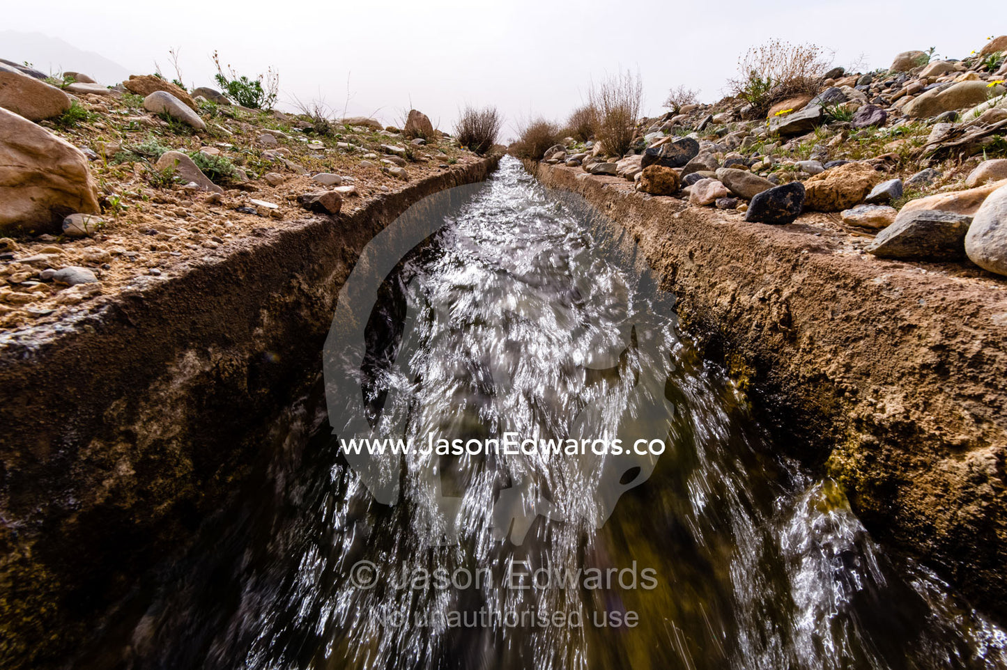 An aqueduct known as a falaj transports water across a barren desert. Barzrud Rural District, Natanz County, Isfahan Province, Islamic Republic of Iran.